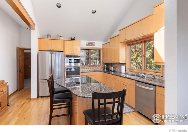 82 Grove Ct, Boulder, CO 80302 - kitchen featuring stainless steel appliances, a sink, high vaulted ceiling, light wood finished floors, and tasteful backsplash
