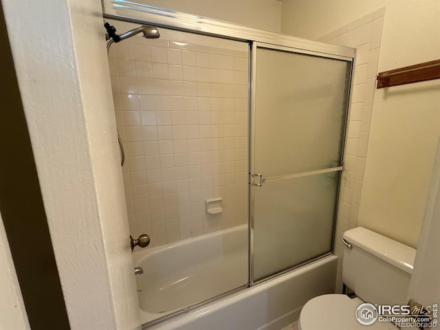 bathroom featuring enclosed tub / shower combo and toilet