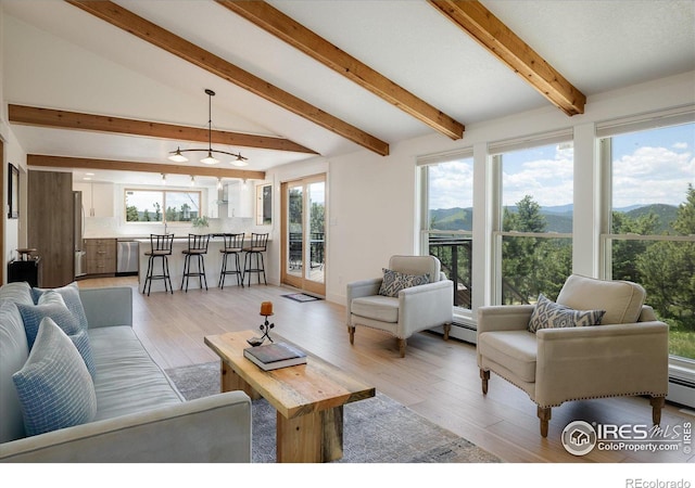 living area with lofted ceiling with beams, a mountain view, and light wood finished floors