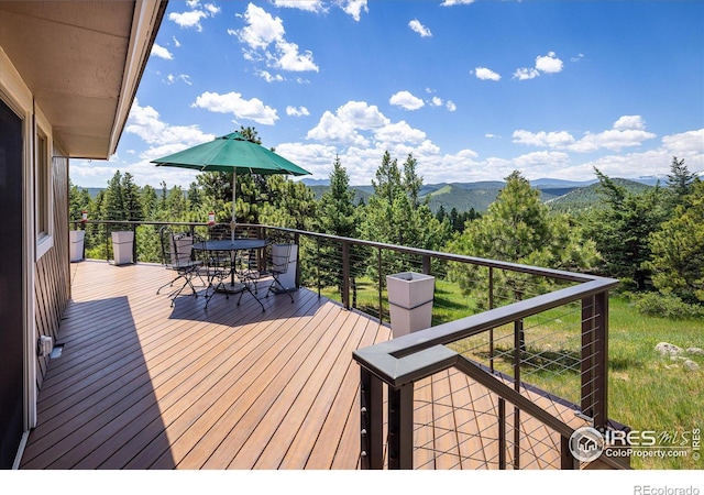 deck featuring outdoor dining area and a mountain view