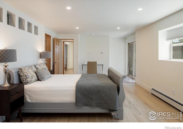 bedroom with recessed lighting, a baseboard heating unit, and light wood-style floors