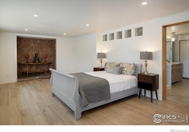 bedroom featuring a sink, light wood-style flooring, and recessed lighting