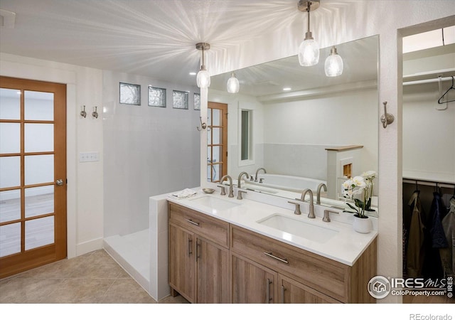 full bathroom featuring a sink, double vanity, tile patterned flooring, and a walk in shower