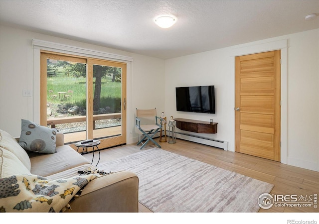 living area with a baseboard radiator, a textured ceiling, and wood finished floors