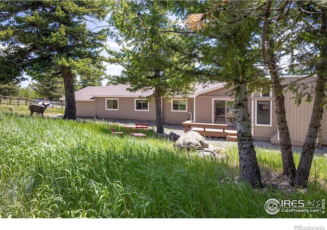 back of house with fence and a wooden deck