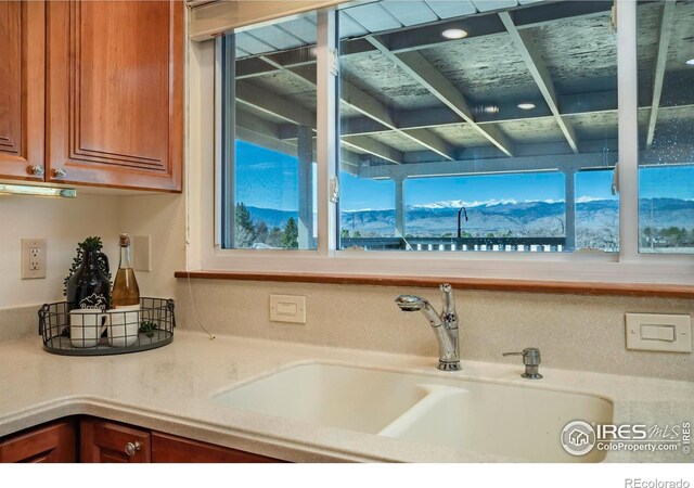 kitchen with a sink, brown cabinets, and light countertops