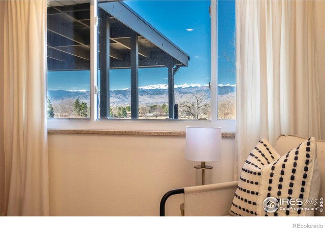 sitting room with a mountain view and plenty of natural light