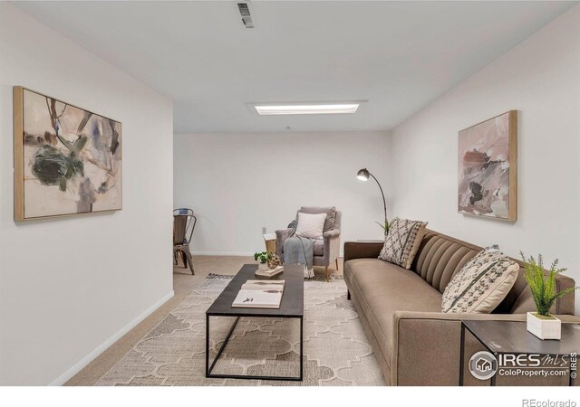 carpeted living room featuring visible vents and baseboards