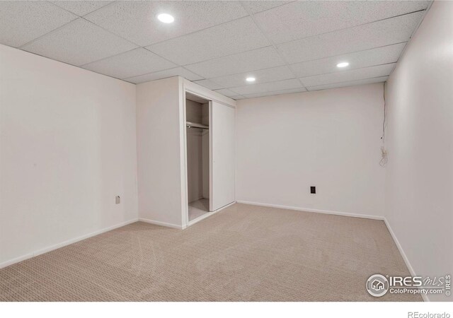 unfurnished bedroom with a drop ceiling, recessed lighting, baseboards, and carpet