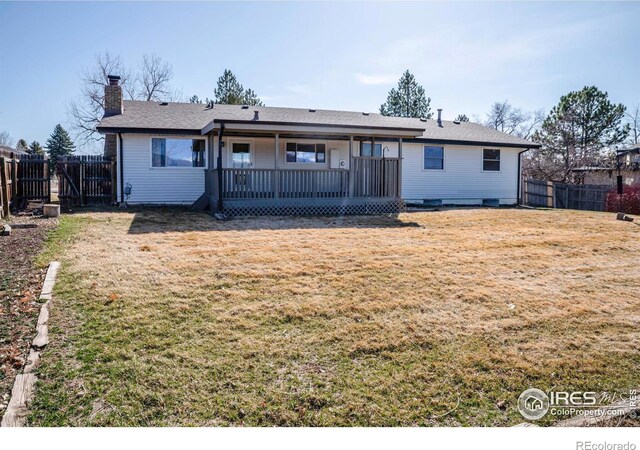 back of house with a lawn, a fenced backyard, and a chimney