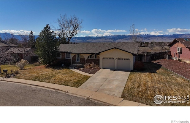 ranch-style home featuring stucco siding, a mountain view, concrete driveway, and a garage