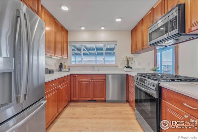 kitchen with brown cabinetry, appliances with stainless steel finishes, and light countertops