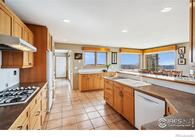 kitchen with tasteful backsplash, light tile patterned floors, recessed lighting, white appliances, and a sink