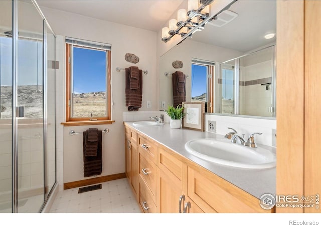 full bathroom featuring tile patterned floors, visible vents, a shower stall, and a sink