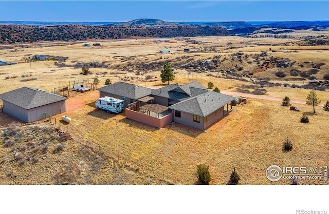 drone / aerial view with view of desert, a rural view, and a mountain view