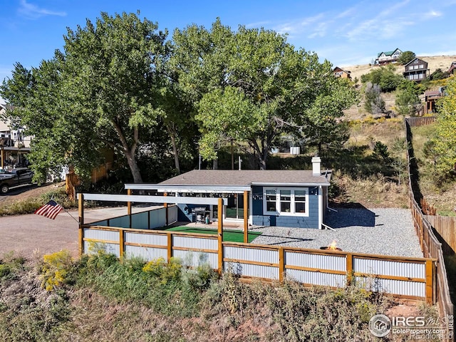 view of front of house featuring a chimney and fence