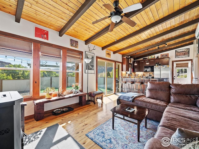 living area featuring a ceiling fan, lofted ceiling with beams, light wood-style floors, and wooden ceiling