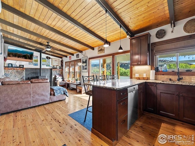 kitchen featuring a peninsula, vaulted ceiling with beams, a sink, stainless steel dishwasher, and tasteful backsplash