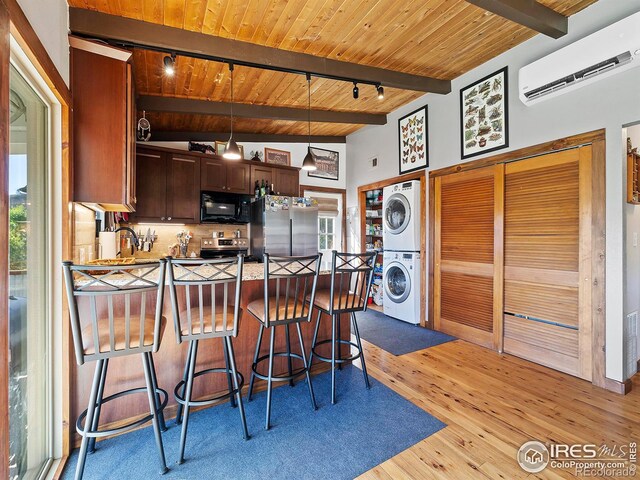 kitchen featuring a wall mounted air conditioner, stacked washer and dryer, appliances with stainless steel finishes, wooden ceiling, and a peninsula