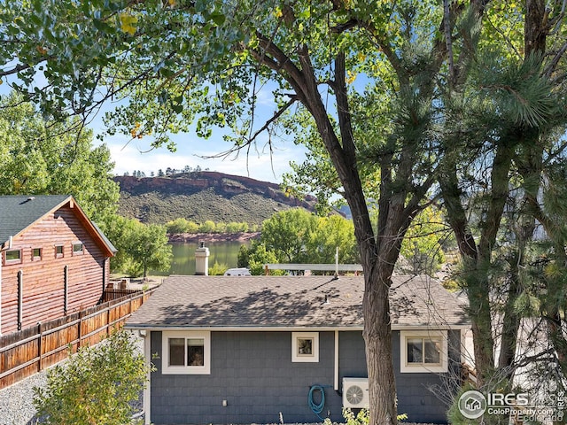 back of property featuring a shingled roof and fence