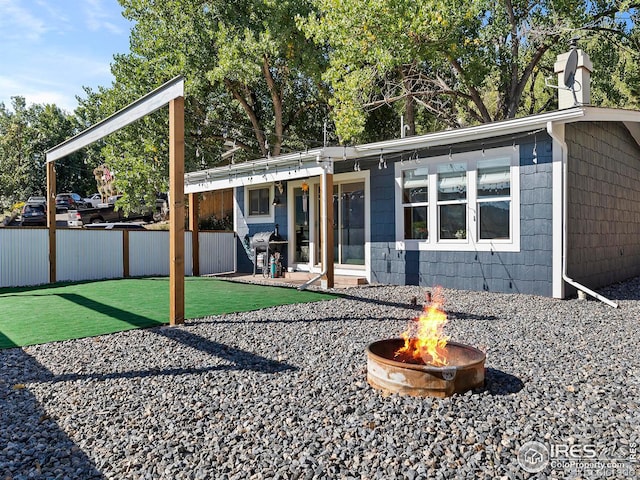 rear view of property with a patio area, a chimney, and an outdoor fire pit