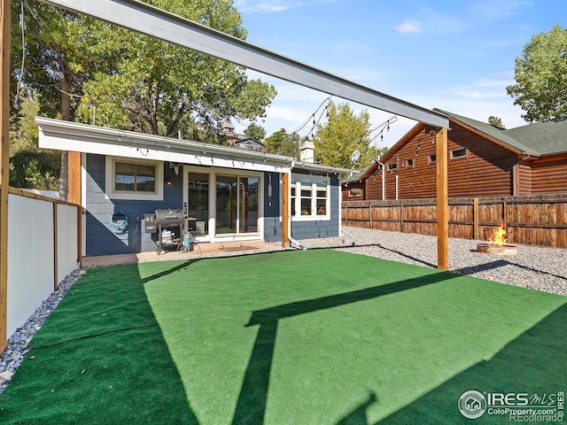 rear view of property with a yard, a patio area, concrete block siding, and a fenced backyard