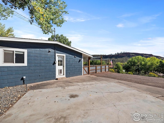 view of property exterior with a mountain view and a patio area