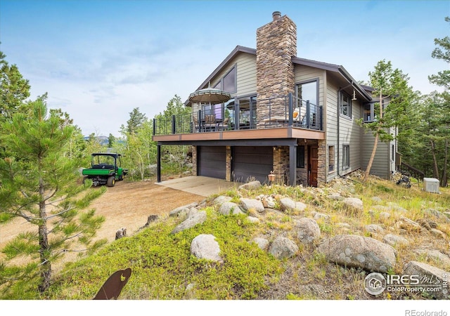 exterior space featuring stone siding, a chimney, and a garage