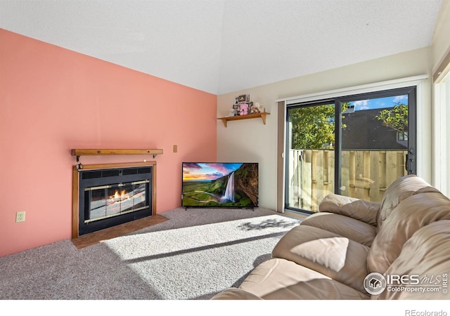 carpeted living room with lofted ceiling and a fireplace with flush hearth