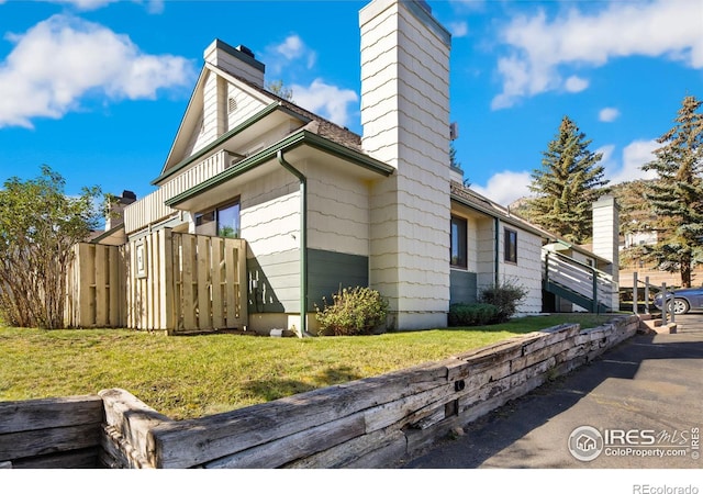 view of property exterior with a chimney and a yard