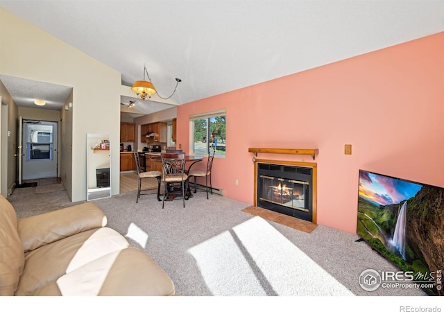 living room featuring a fireplace with flush hearth, light colored carpet, and vaulted ceiling