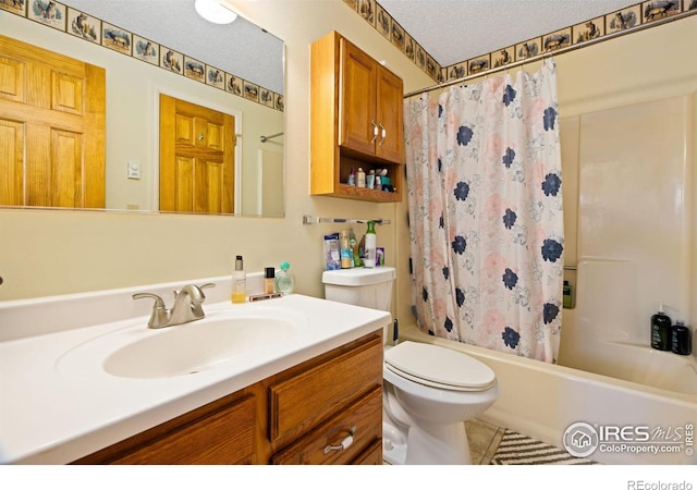 full bath featuring tile patterned flooring, toilet, shower / bath combo with shower curtain, a textured ceiling, and vanity