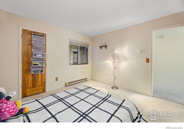 carpeted bedroom with a baseboard radiator and a textured ceiling