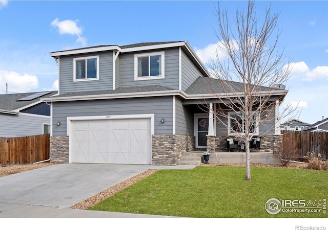 view of front of house featuring a front yard, fence, a porch, a garage, and stone siding