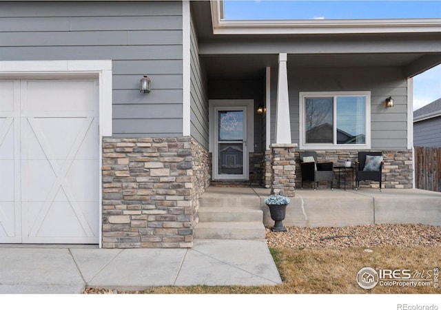 property entrance with stone siding and a porch