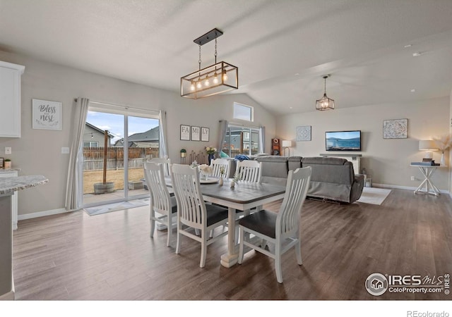 dining room with lofted ceiling, wood finished floors, and baseboards