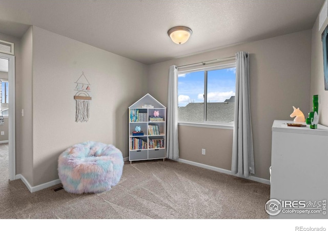 rec room with carpet flooring, baseboards, and a textured ceiling