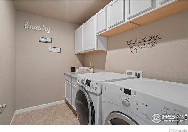 washroom with cabinet space, independent washer and dryer, and baseboards