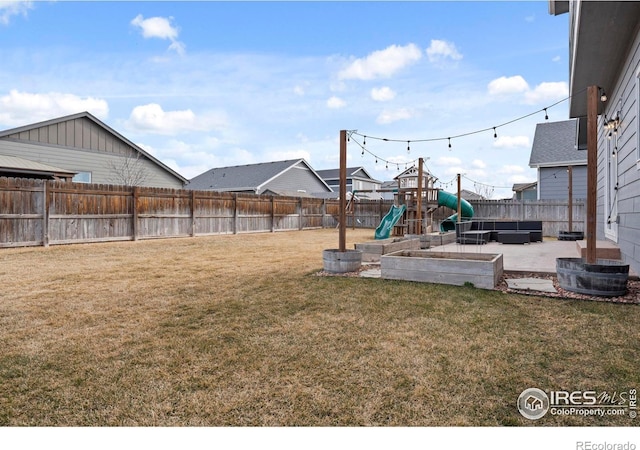 view of yard with a patio area, a playground, and a fenced backyard