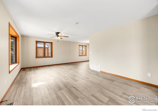 spare room featuring visible vents, baseboards, and light wood-style floors