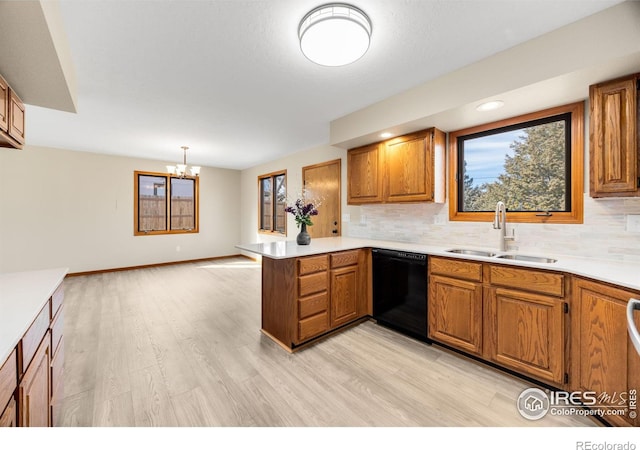 kitchen featuring a wealth of natural light, dishwasher, a peninsula, and a sink