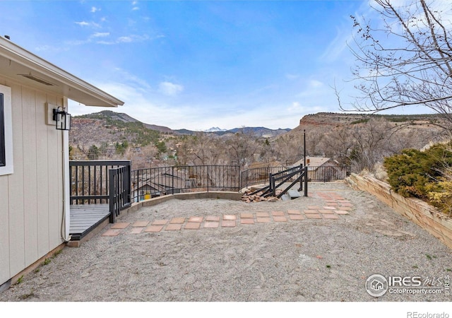 view of yard with a patio, fence, and a mountain view