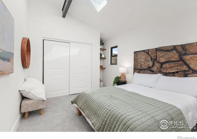 carpeted bedroom with a closet and lofted ceiling with skylight