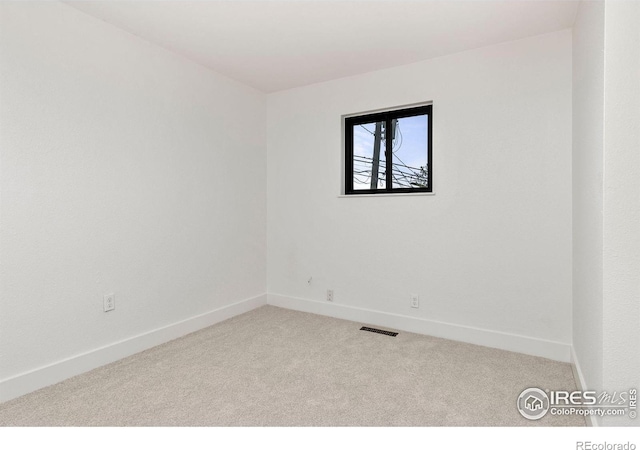 empty room with visible vents, baseboards, and carpet