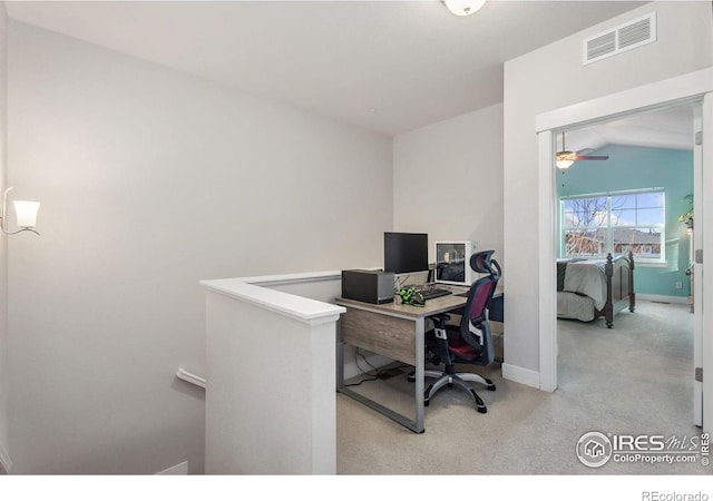 carpeted office featuring lofted ceiling, baseboards, and visible vents