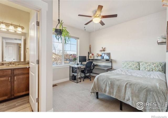 bedroom with visible vents, light colored carpet, baseboards, and a sink