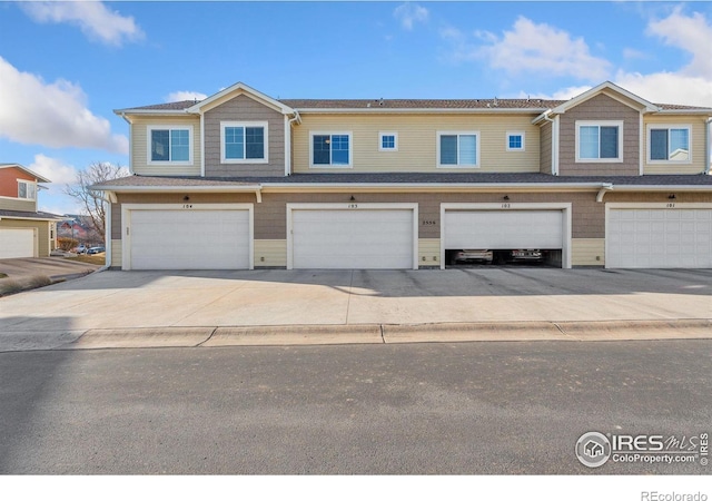 view of property with a garage and driveway