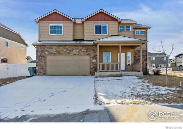 view of front of home with a garage, covered porch, board and batten siding, and fence