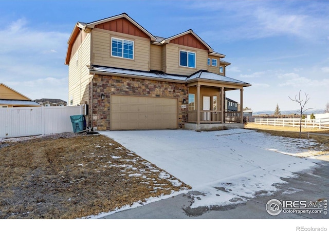 view of front of home with a porch, board and batten siding, driveway, and fence