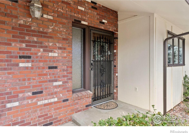 doorway to property featuring brick siding